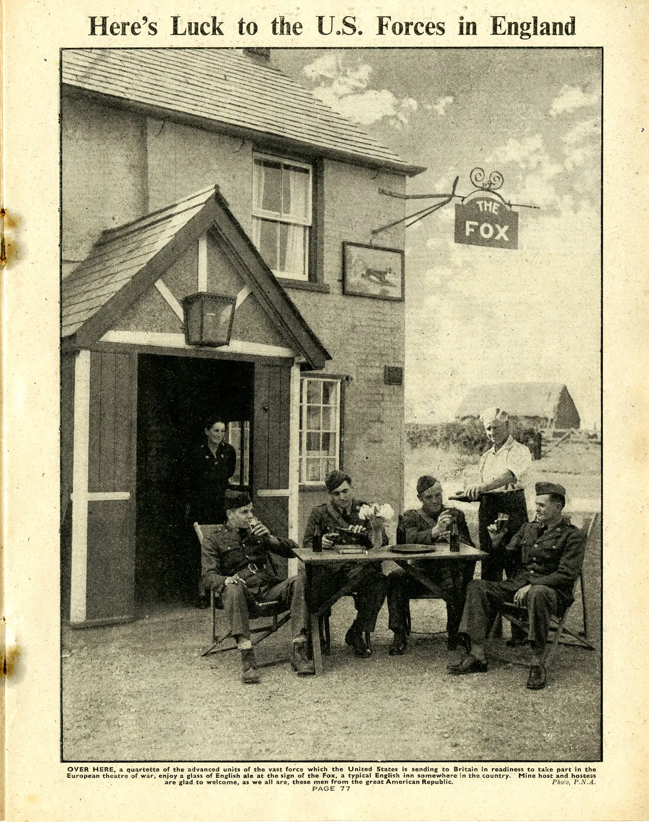 A page of "The War Illustrated" showing Four American soldiers in dress uniforms relaxing and drinking pints of beer outside a modest English inn, "The Fox", as their smiling English hosts look on. They are somewhere in the English countryside, with a thatch roof barn in the background.